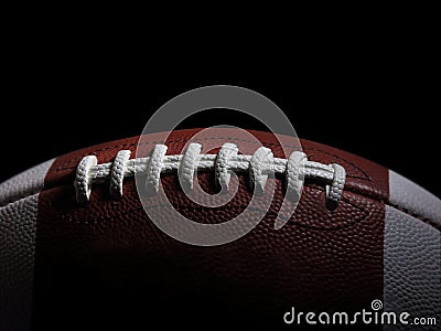 Closeup of an American Football Game Ball Against a Black Background Stock Photo