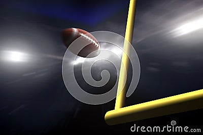 American football over goal post at night Stock Photo