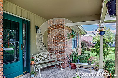 American House Front Porch Decorated with Plants and Bench, Stone and Wood Construction Architectural Feature Stock Photo