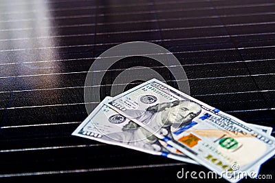 American money on solar panel surface. Renewable energy cost Stock Photo