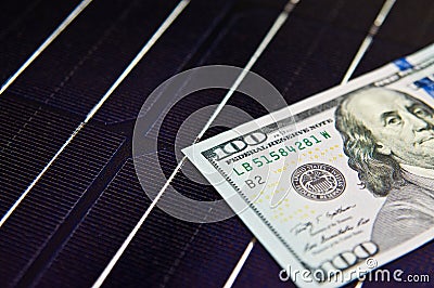 American money on solar panel surface. Renewable energy cost Stock Photo