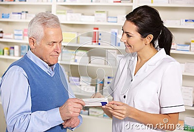 American pharmacist serving senior man in pharmacy Stock Photo