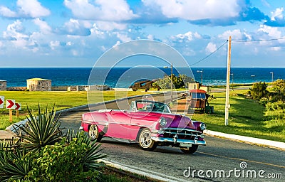 American red pink 1954 convertible vintage car on the fortress el Morro near the beach in Havana Cuba - Serie Cuba Reportage Stock Photo