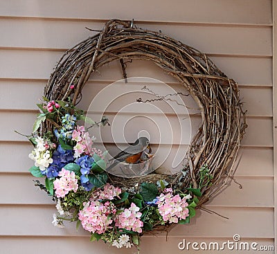 Robin feeding chicks in wreath nest Stock Photo