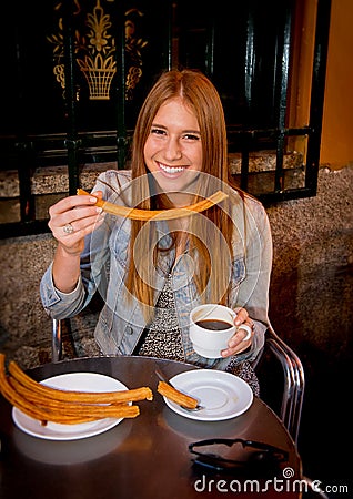 American student tourist girl sitting having spanish typical hot chocolate with churros smiling happy Stock Photo