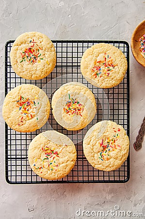 American style round cookies with confetti (shortbread) on a wire rack on a grey stone backdrop. Stock Photo