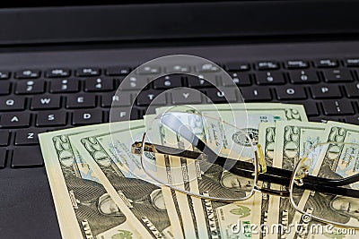 American twenty dollar banknotes, glasses on the keyboard laptop money on the Internet, freelancer Stock Photo