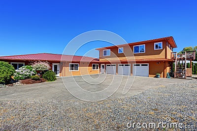 American waterfront house, orange exterior paint and three garage spaces Stock Photo