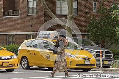 The American woman crosses the pedestrian crossing while the tax Editorial Stock Photo