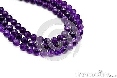 Amethyst bead strands on white background. Purple or violet crystal stone. Stock Photo