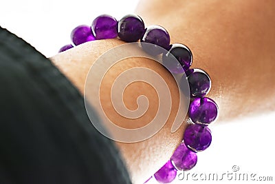 Amethyst bracelet on the wrist. Spiritual and healing crystal gemstone. Purple or violet crystal stone. Stock Photo