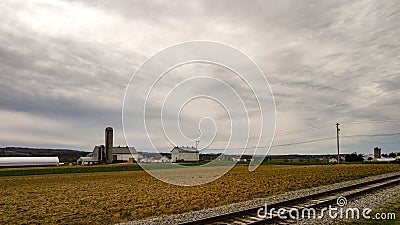 An Amish farm with barns and silo on a cloudy day. Stock Photo