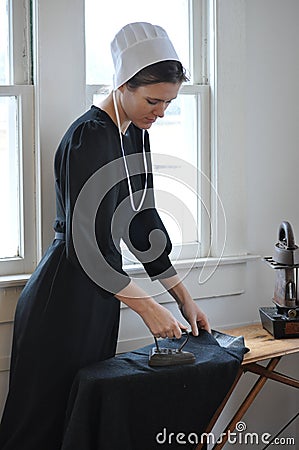 Amish Young Woman Ironing Stock Photo