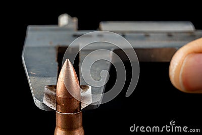 Ammunition of a high-speed rifle. Measurement using a rifle bullet diameter caliper Stock Photo