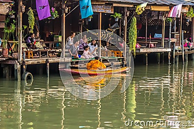 Amphawa Floating Market,Samut Songkhram Province,Thailand on April 13,2019:Buddhist monk rows the boat to receive food offerings f Editorial Stock Photo