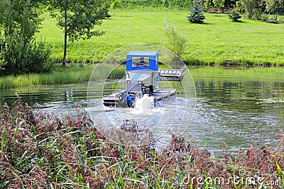Amphibious machine mowing algae on still water Stock Photo