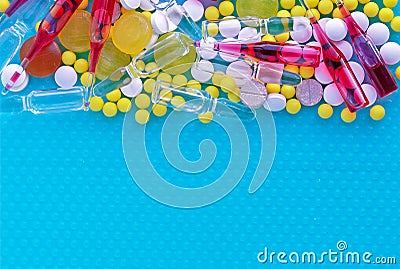 Ampoules for injection, pills and vitamins on a blue background. Medical concept Stock Photo