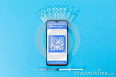 Ampules with vaccines, syringe and smartphone with electronic Immunity passport. Blue background. Concept of vaccination from Stock Photo