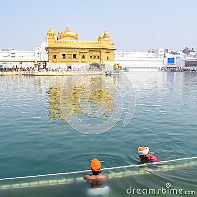 Amritsar, India - February 26 2023 - Unidentified devotees taking holy dip in sarovar at Golden Temple Editorial Stock Photo