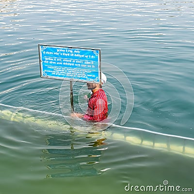 Amritsar, India - February 26 2023 - Unidentified devotees taking holy dip in sarovar at Golden Temple Editorial Stock Photo