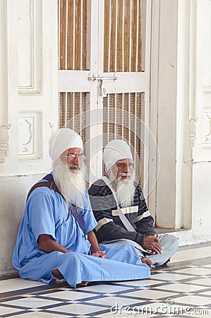 Amritsar, India - November 21, 2011: The Sikh pilgrims meditates on the Amrit Sarovar lake in the Golden Temple complex. Amritsar Editorial Stock Photo
