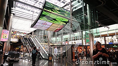 Amsterdam Airport Schiphol. Escalators. Airport terminal, shopping arcade with shops and people in transit Editorial Stock Photo
