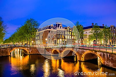 Amsterdam canal with typical dutch houses during twilight blue hour in Holland, Netherlands. Stock Photo