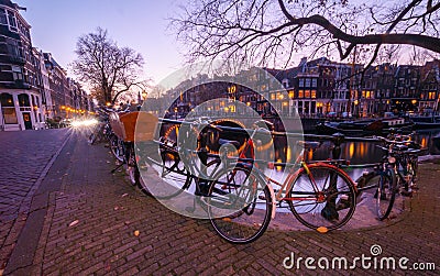 Amsterdam canal view and bicycles on the bridge in evening Stock Photo