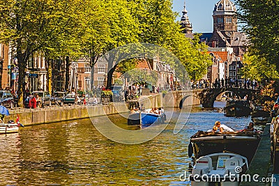 Amsterdam Canals and people enjoying spare time on their boats on a sunny day Stock Photo