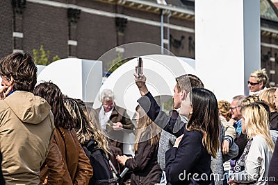 Amsterdam , Netherlands - April 31, 2017 : Asian lady taking selfies while people walking around in the streets Editorial Stock Photo