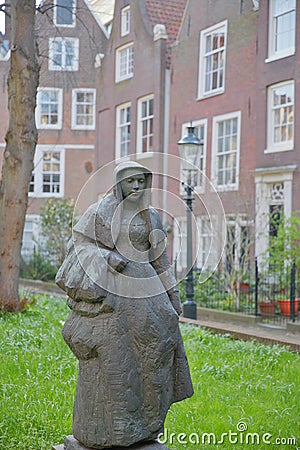 Close-up on the statue of a Beguine, located in the internal courtyard of Begijnhof, one of the oldest hofjes in Amsterdam Editorial Stock Photo