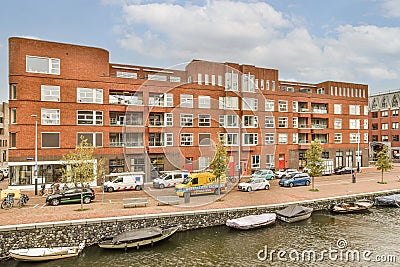 a large brick building with boats docked in front Editorial Stock Photo