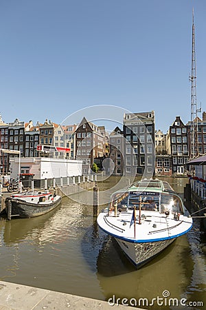 Jetty with pleasure ships on Damrak street in the center of Amsterdam Editorial Stock Photo