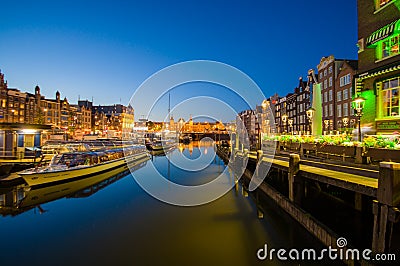 Amsterdam, Netherlands - July 10, 2015: Water channels by night, beautiful dark blue sky and city lights on both sides Editorial Stock Photo