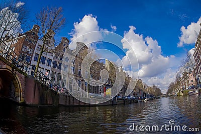 AMSTERDAM, NETHERLANDS, MARCH, 10 2018: Beautiful outdoor view Amsterdam canals with bridge and typical dutch houses Editorial Stock Photo