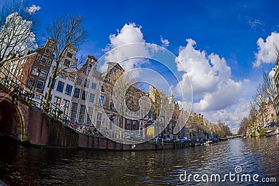 AMSTERDAM, NETHERLANDS, MARCH, 10 2018: Beautiful outdoor view Amsterdam canals with bridge and typical dutch houses Editorial Stock Photo