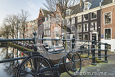 Dutch canal houses with bike leaning against bridge Editorial Stock Photo