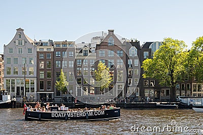 Amsterdam, The Netherlands, May, 2018: Amstel River waterfront on a sunny day with typical houses and boats along the river. Editorial Stock Photo