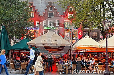 Amsterdam, The Netherlands May. Tourists and locals drinking and eating at the Rembrandtplein square with old colorful Editorial Stock Photo