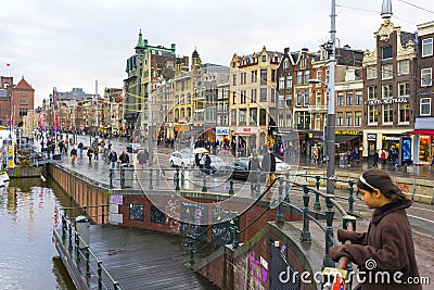 People walking on Damrak avenue at evening light in Amsterdam, Netherlands Editorial Stock Photo