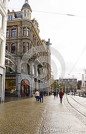 People walking on Damrak avenue at evening light in Amsterdam, Netherlands Editorial Stock Photo