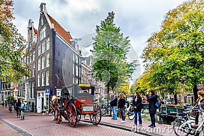 Horse and Carriage carrying tourists in the Jordaan neighborhood of Amsterdam Editorial Stock Photo