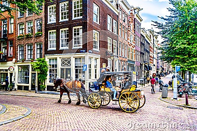 Horse and Carriage carrying tourists in the Jordaan neighborhood of Amsterdam Editorial Stock Photo