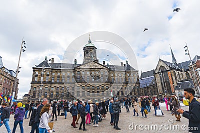 02.26.2023 Amsterdam, Netherlands. Tourists visiting The Royal Palace on the Dam in Amsterdam. Cloudy weather. Editorial Stock Photo