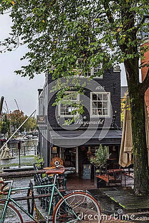 Amsterdam, Netherlands, 10/12/2019: Typical Dutch canal house with bridge and parked bike Editorial Stock Photo