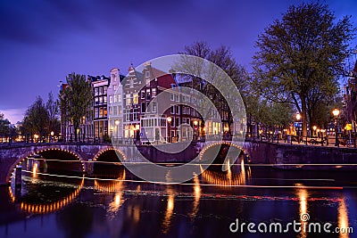 Amsterdam by night with floating boats on the river canal , evening time , travelling to Netherlands Stock Photo