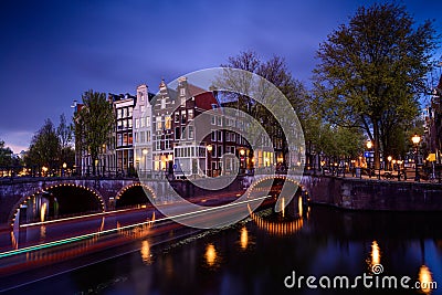 Amsterdam by night with floating boats on the river canal , evening time , travelling to Netherlands Stock Photo