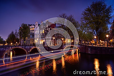 Amsterdam by night with floating boats on the river canal , evening time , travelling to Netherlands Stock Photo