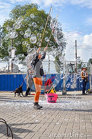 AMSTERDAM - SEPTEMBER 18, 2015: Woman making huge bubble balloon Editorial Stock Photo