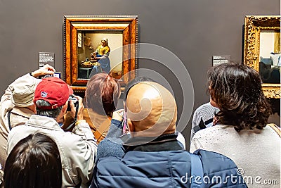 Amsterdam-Visitors looking at the painting milkmaid by Johannes Vermeer Editorial Stock Photo